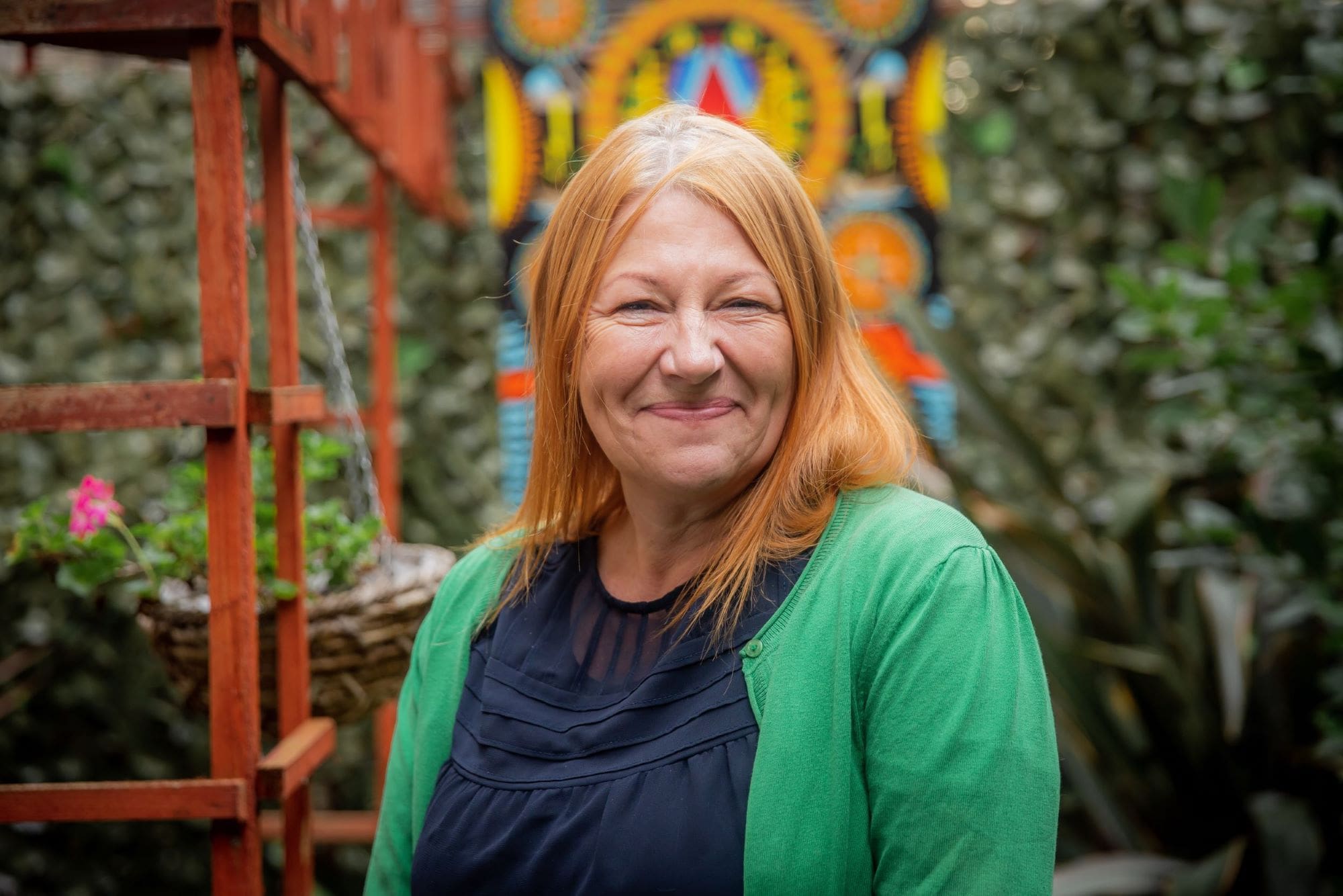 Portrait of smiling woman with red hair and green cardigan